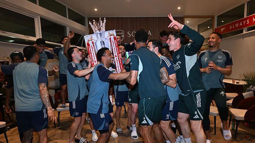 Arsenal players celebrating in the dressing room after winning the premier league
